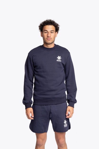 Man wearing the Osaka navy basic unisex sweater with logo in white. Front view