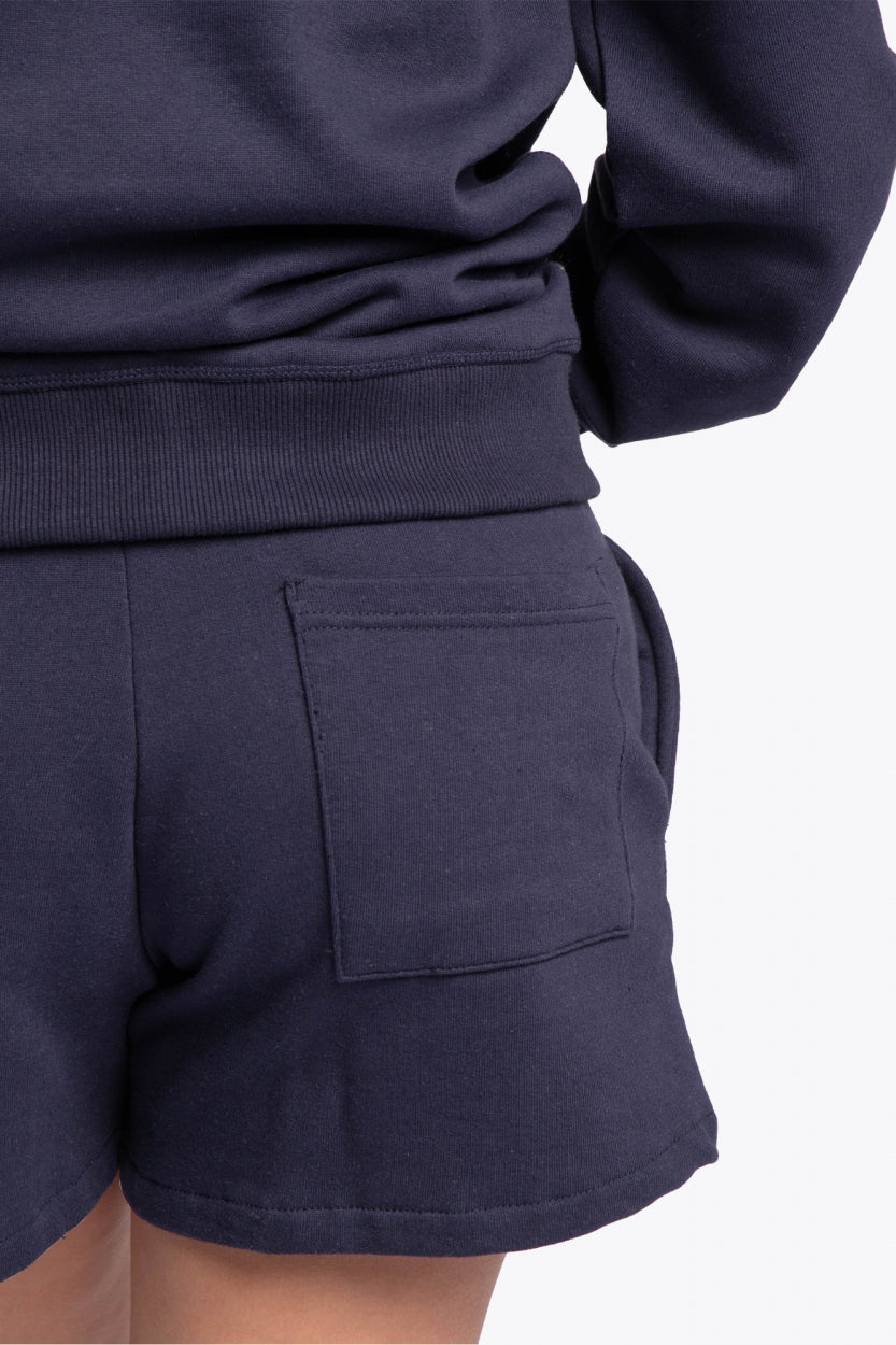 Woman wearing the Osaka navy basic unisex sweater with logo in white. Back detail view