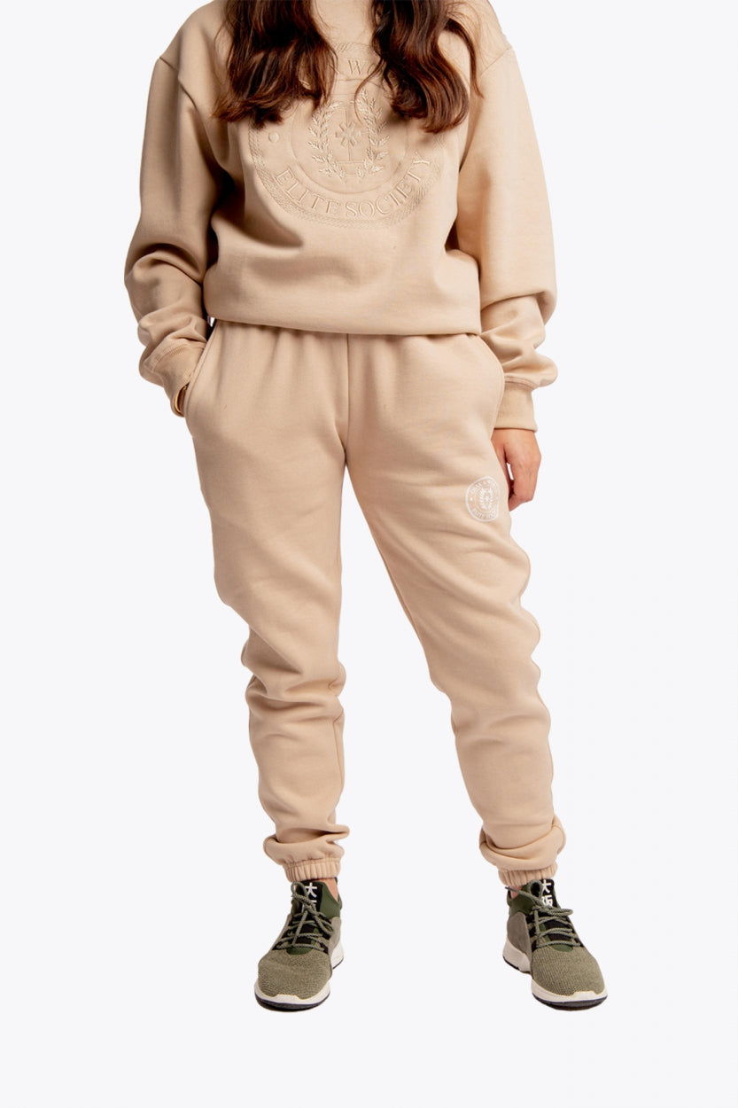 Model wearing the Osaka unisex sweatpants in stone with logo in white. Front view