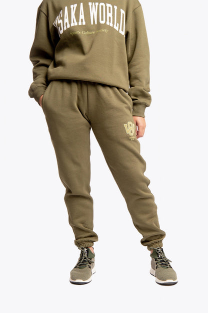 Model wearing the Osaka unisex sweatpants in army green with logo in yellow.  Front view