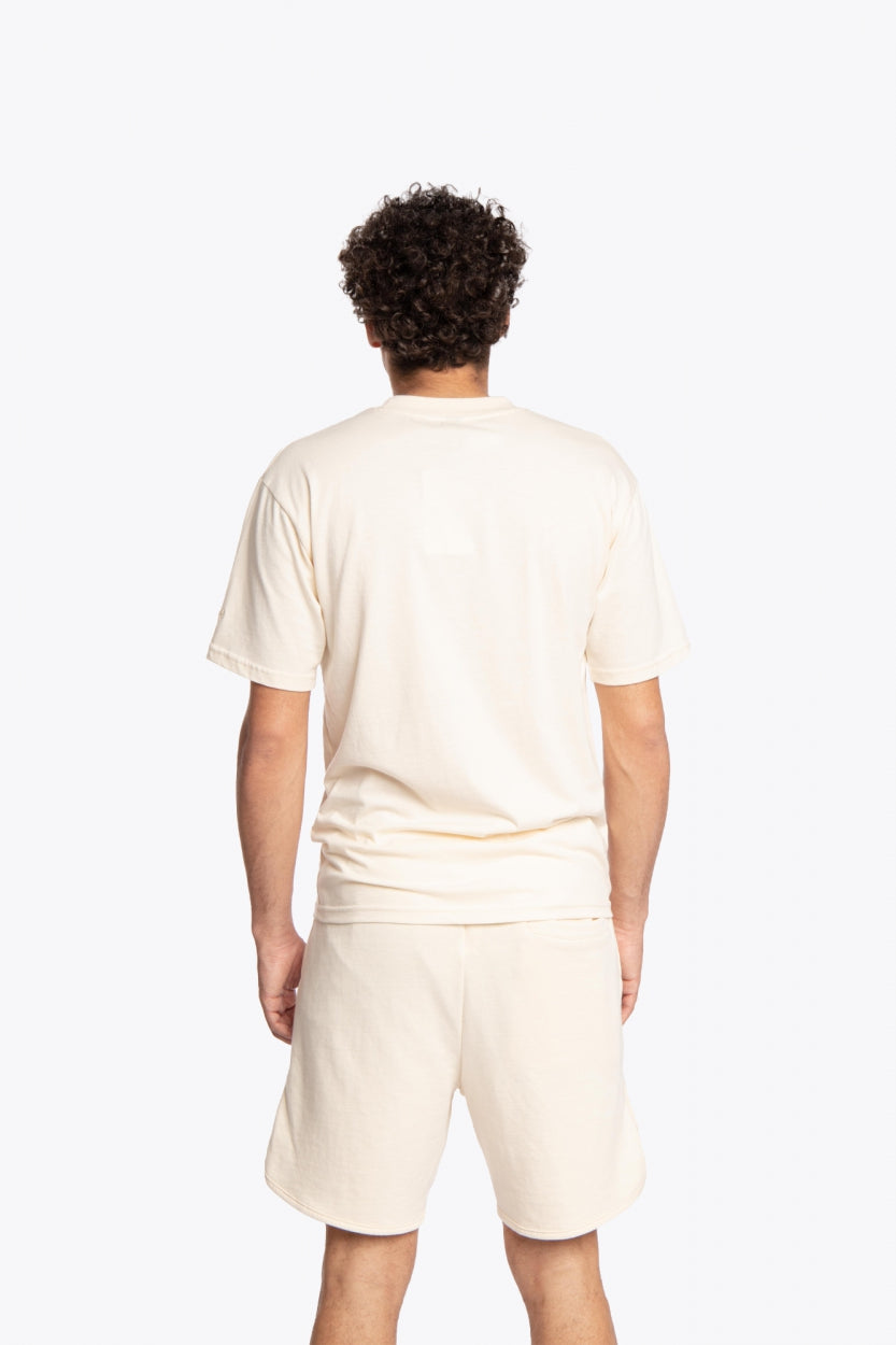 Man wearing the Osaka unisex tee in cream with logo in grey. Back view
