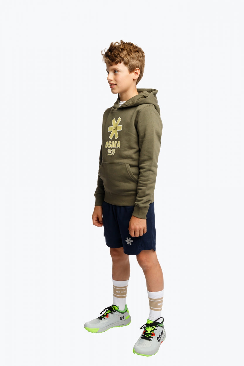 Boy wearing the Osaka kids hoodie in khaki with yellow logo. Full side view