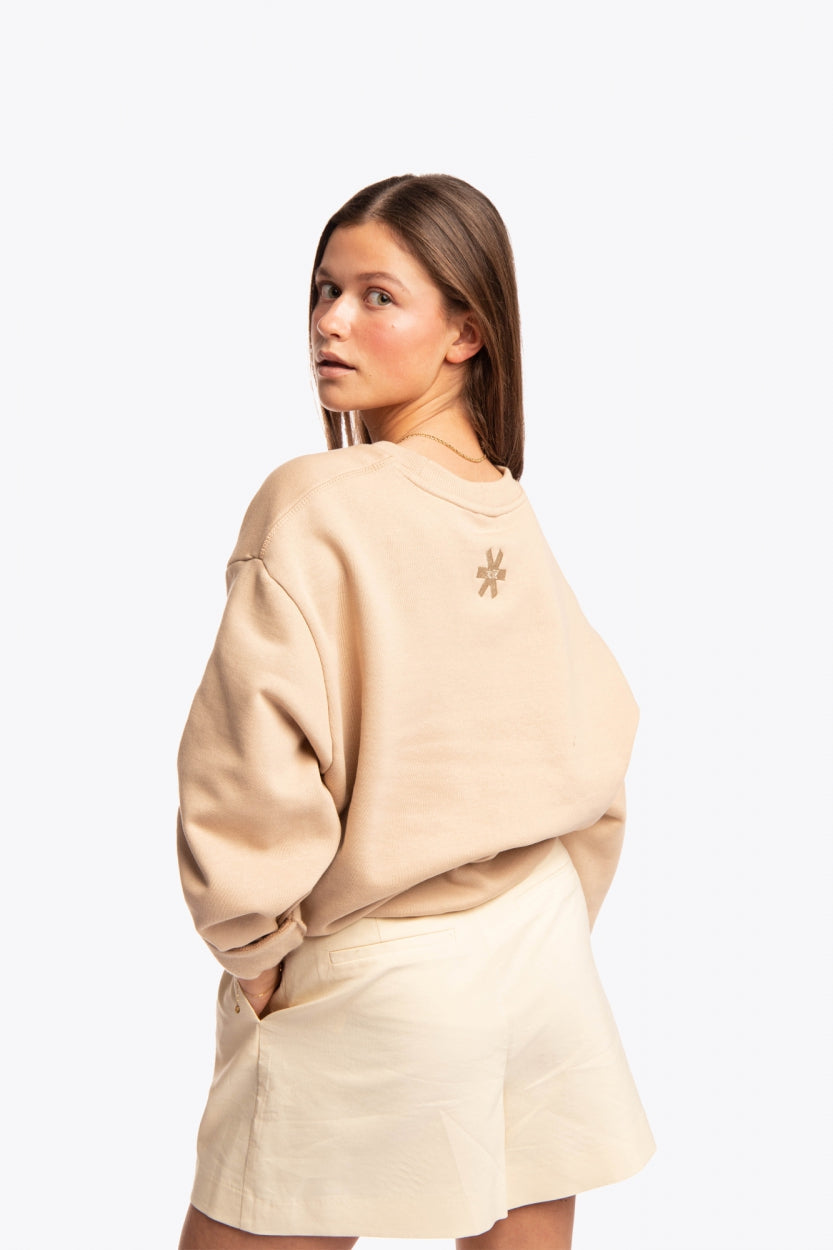 Woman wearing the Osaka x Buenas Open sweater in stone. Back view