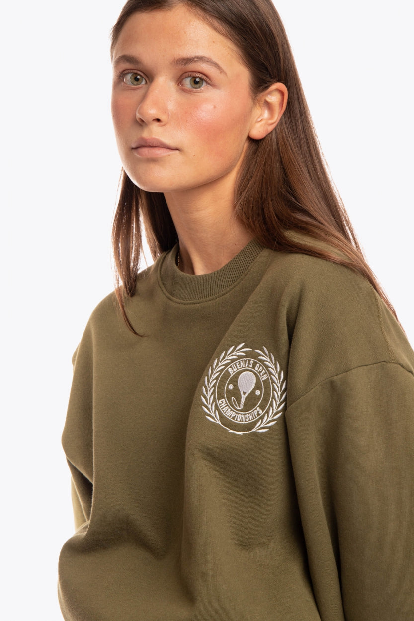 Woman wearing the Osaka x Buenas Open sweater in army green. Front view