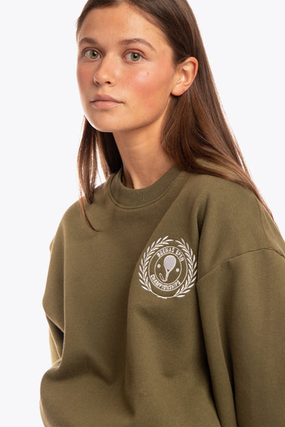 Woman wearing the Osaka x Buenas Open sweater in army green. Front view