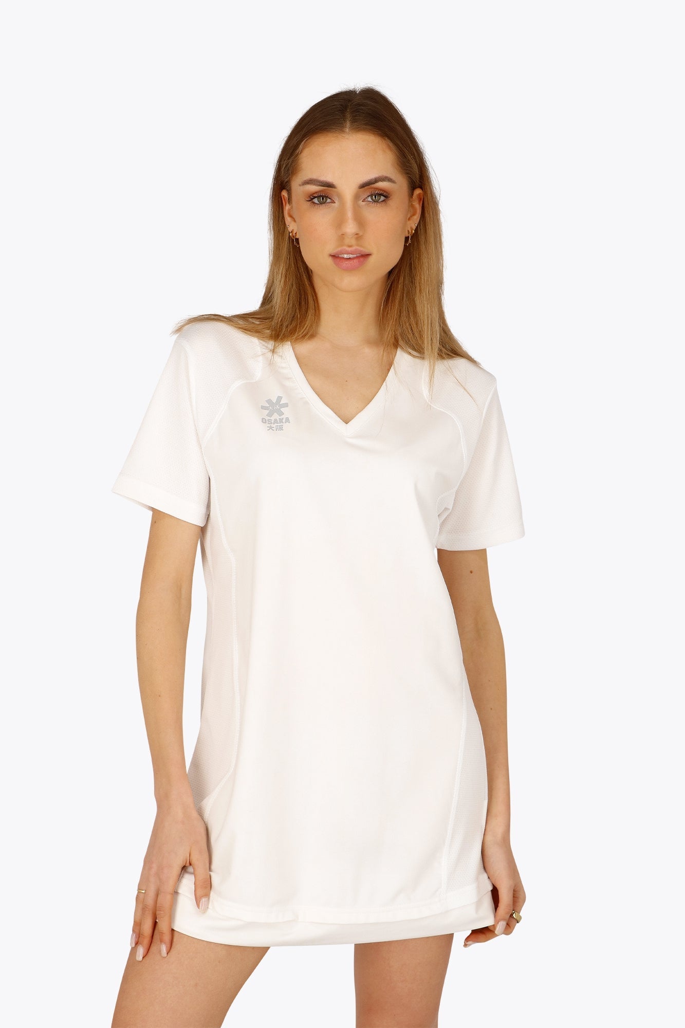 Woman wearing the Osaka women v-neck tech dress in white with logo in grey. Front view