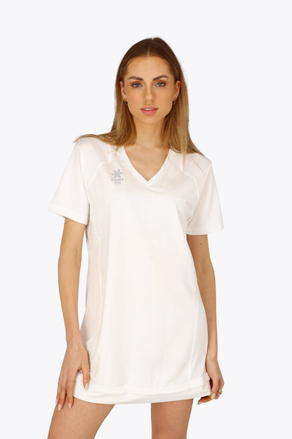 Woman wearing the Osaka women v-neck tech dress in white with logo in grey. Front view
