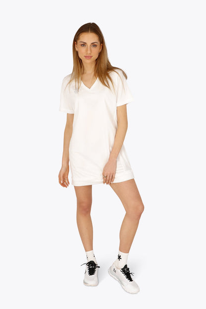 Woman wearing the Osaka women v-neck tech dress in white with logo in grey. Front view