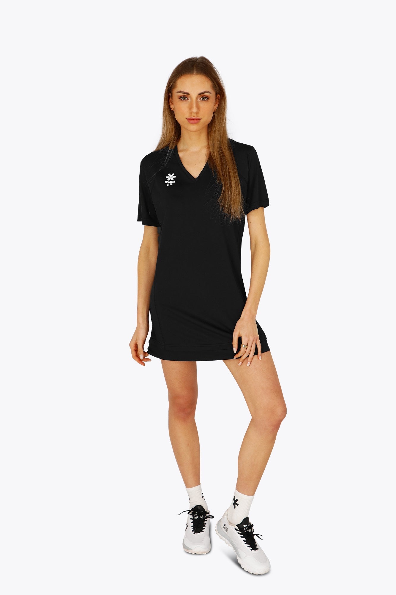 Woman wearing the Osaka women v-neck tech dress in black with logo in grey. Front view