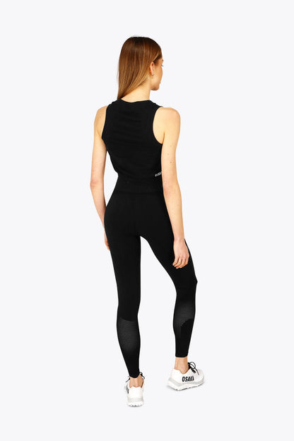 Woman wearing the Osaka women tech tank top in black with logo in grey. Back view