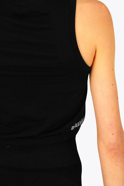 Woman wearing the Osaka women tech tank top in black with logo in grey. Back detail side view