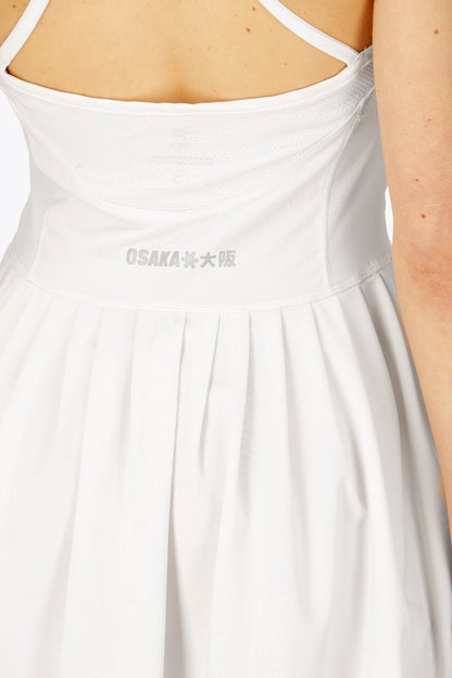 Woman wearing the Osaka women pleated tech dress in white with grey logo. Back detail logo view