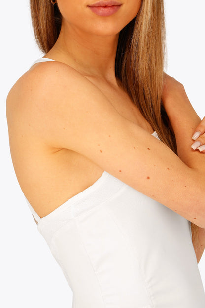 Woman wearing the Osaka women pleated tech dress in white with grey logo. Side detail view