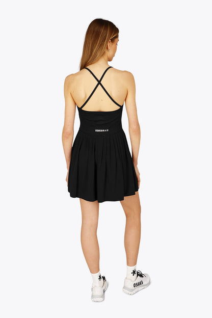 Woman wearing the Osaka women pleated tech dress in black with grey logo. Back view