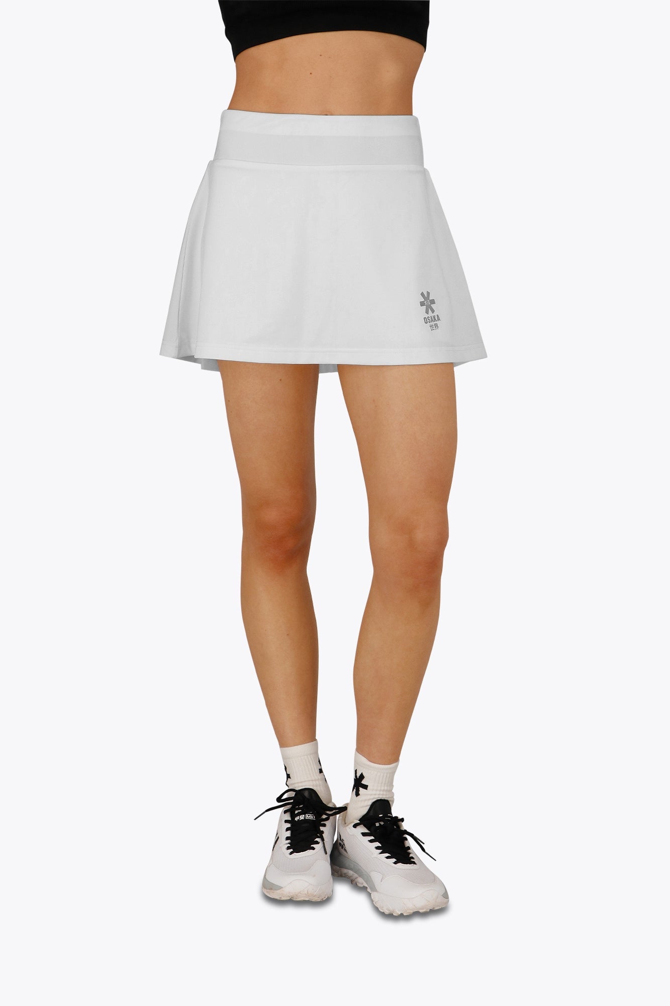 Woman wearing the Osaka women floucy skort white with logo in grey. Front view