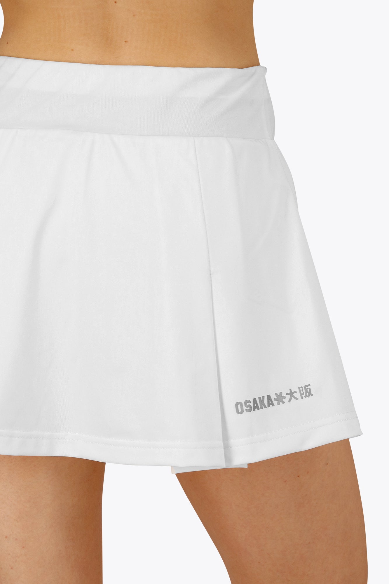 Woman wearing the Osaka women floucy skort white with logo in grey. Back detail logoview