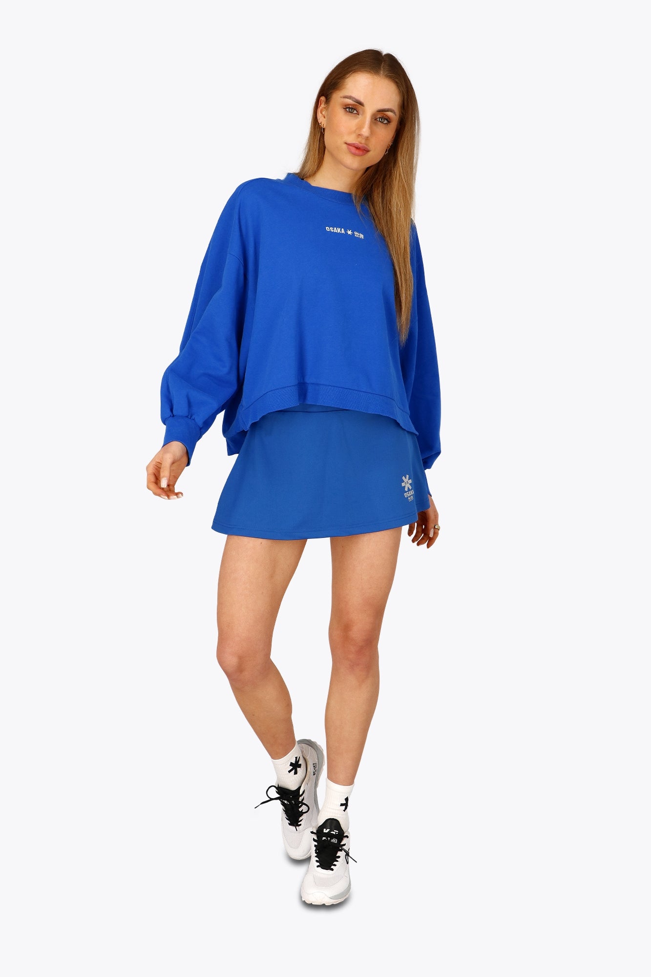 Woman wearing the Osaka women floucy skort princess blue with logo in grey. Front view