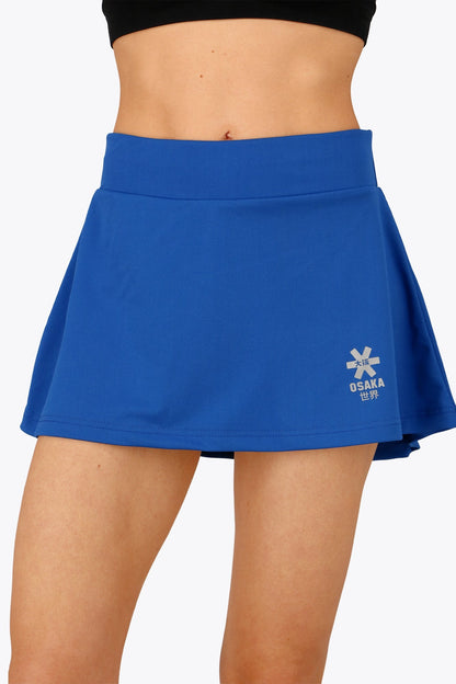 Woman wearing the Osaka women floucy skort princess blue with logo in grey. Front view
