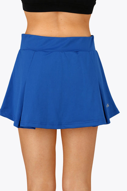 Woman wearing the Osaka women floucy skort princess blue with logo in grey. Back view