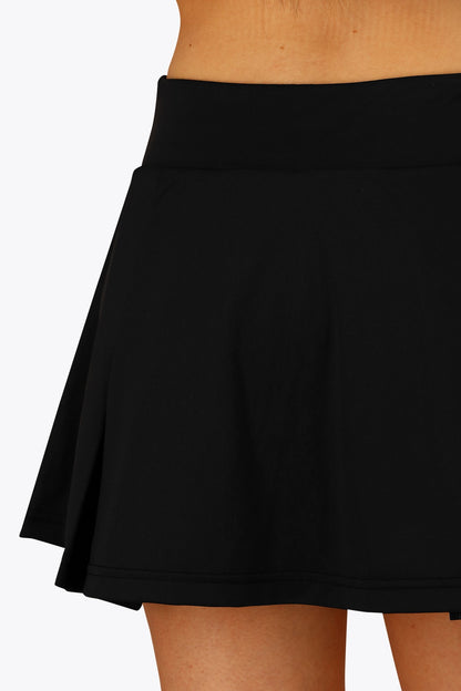 Woman wearing the Osaka women floucy skort black with logo in grey. Back detail view
