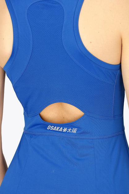 Woman wearing the Osaka women floucy dress princess blue with logo in grey. Back detail open back view