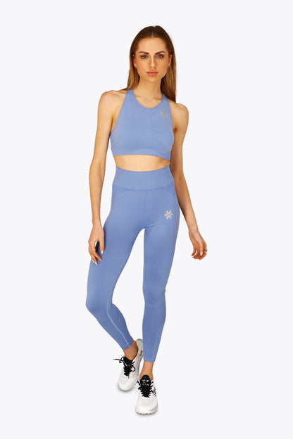 Woman wearing the Osaka women shimuresu leggin in manor blue with logo in grey. Front view