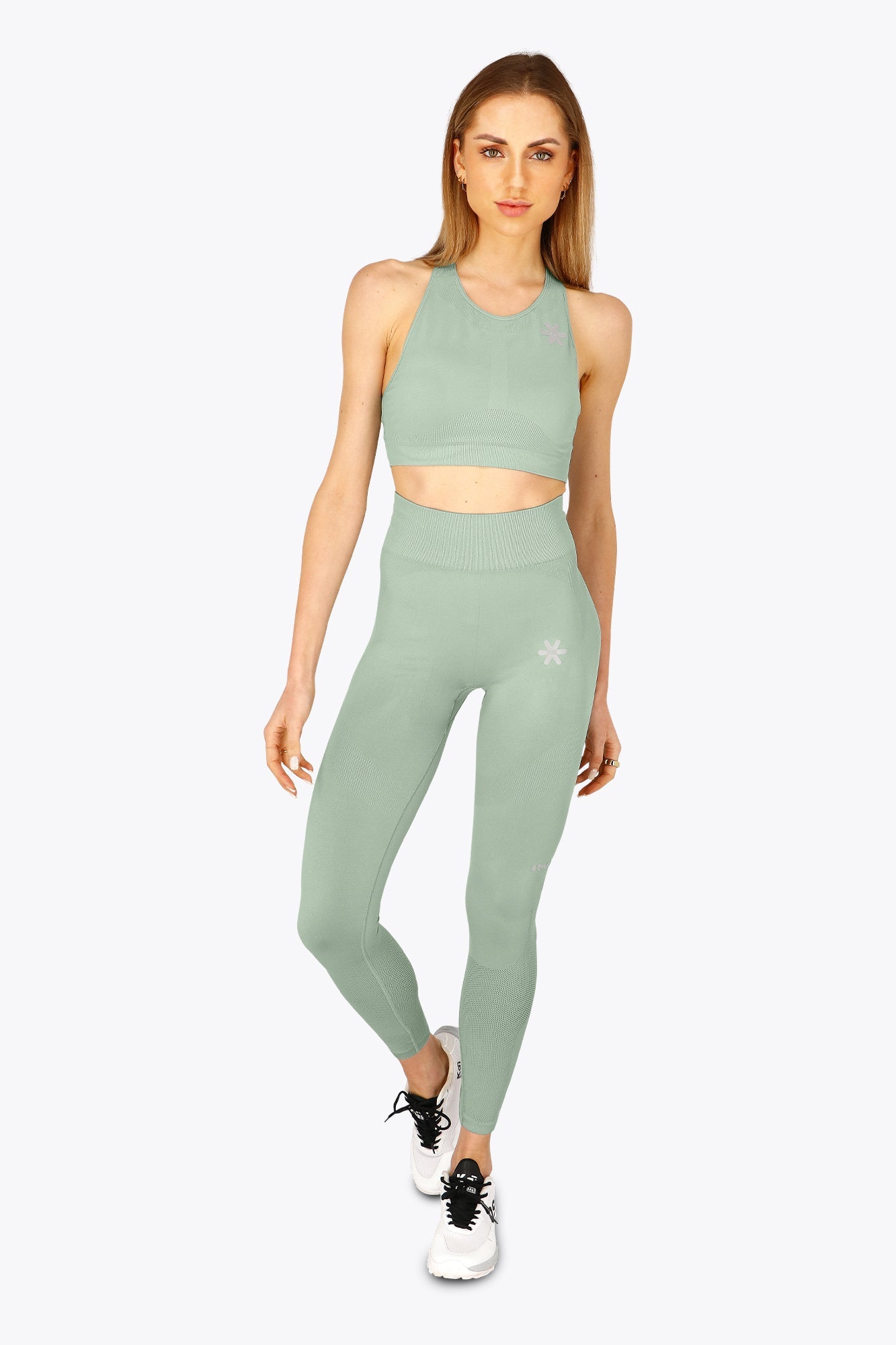 Woman wearing the Osaka women shimuresu leggin in jadeite with logo in grey. Front view