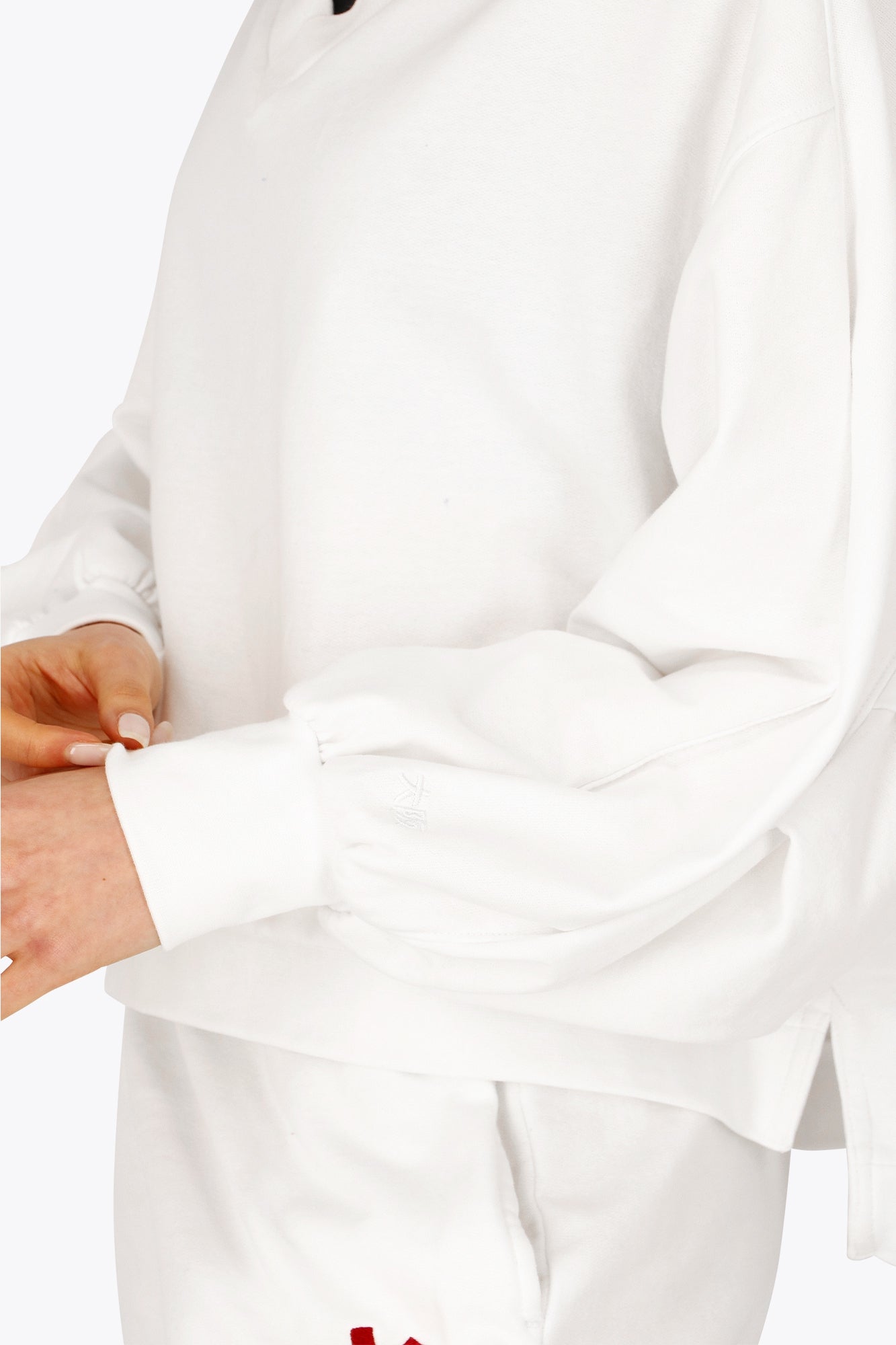 Osaka women v-neck cropped sweater white with logo in red. Front detail sleeve view