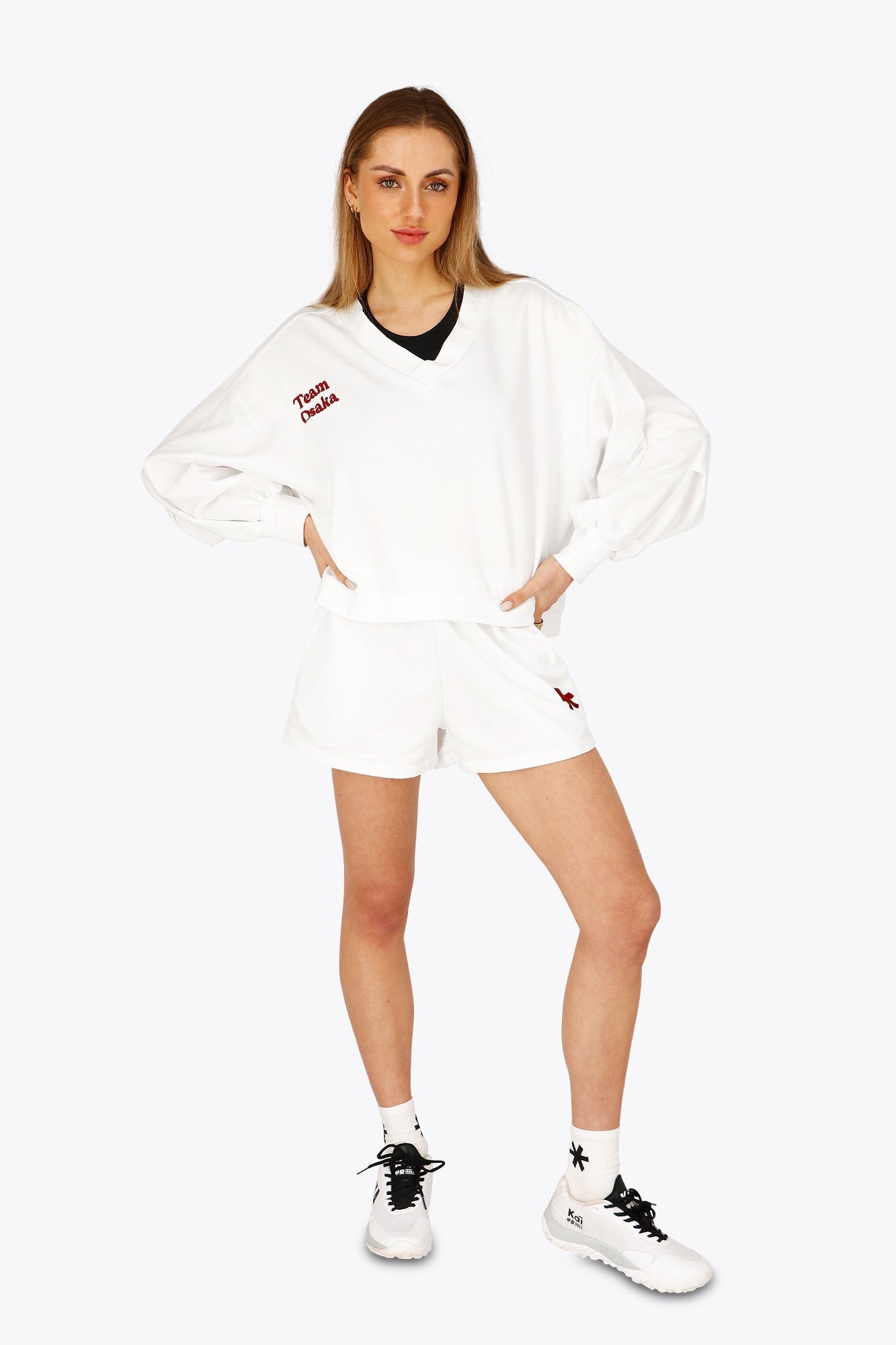 Woman wearing the Osaka women v-neck cropped sweater white with logo in red. Front view