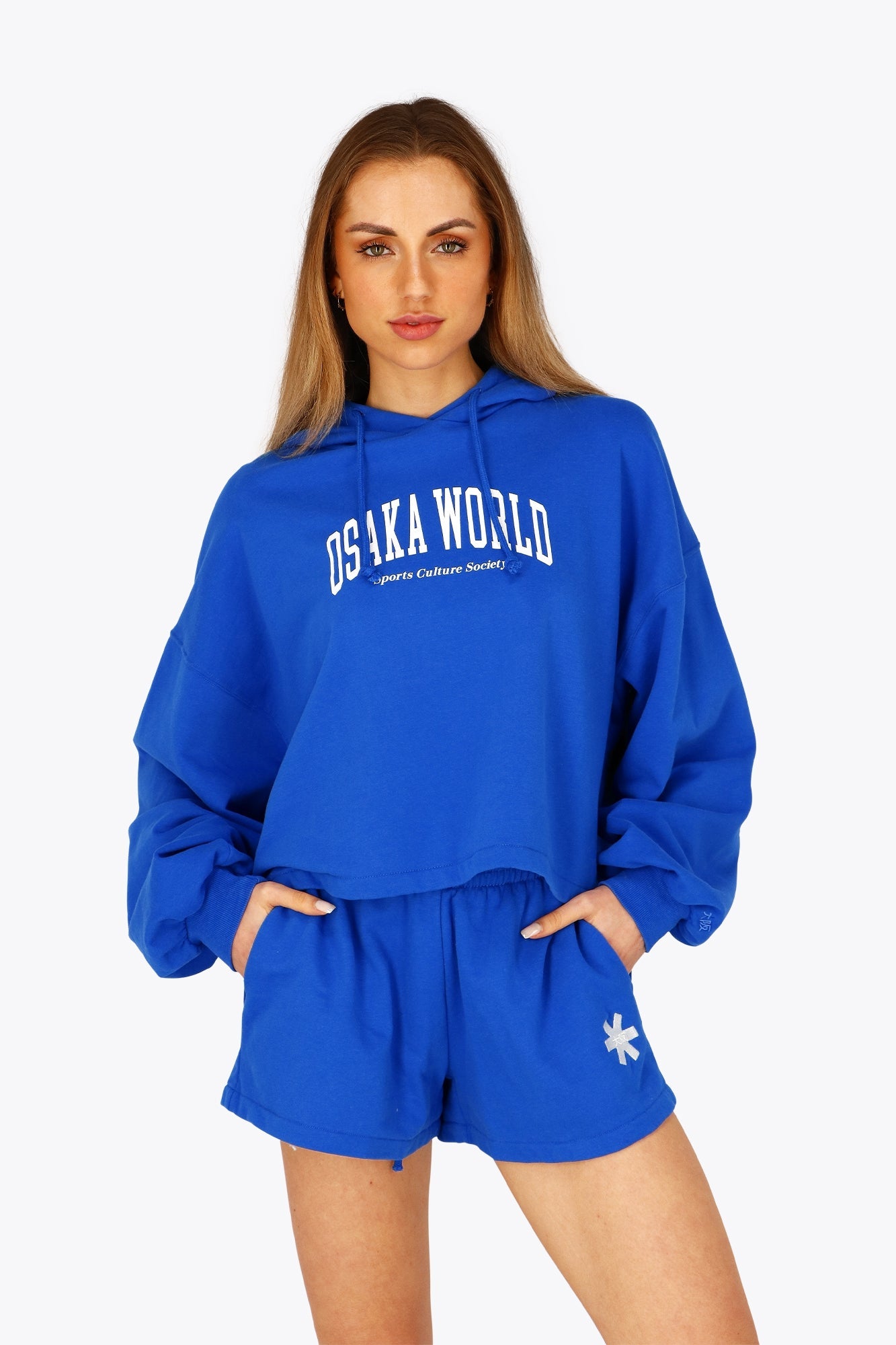 Woman wearing the Osaka women cropped hoodie inprincess blue with college logo in white. Front view
