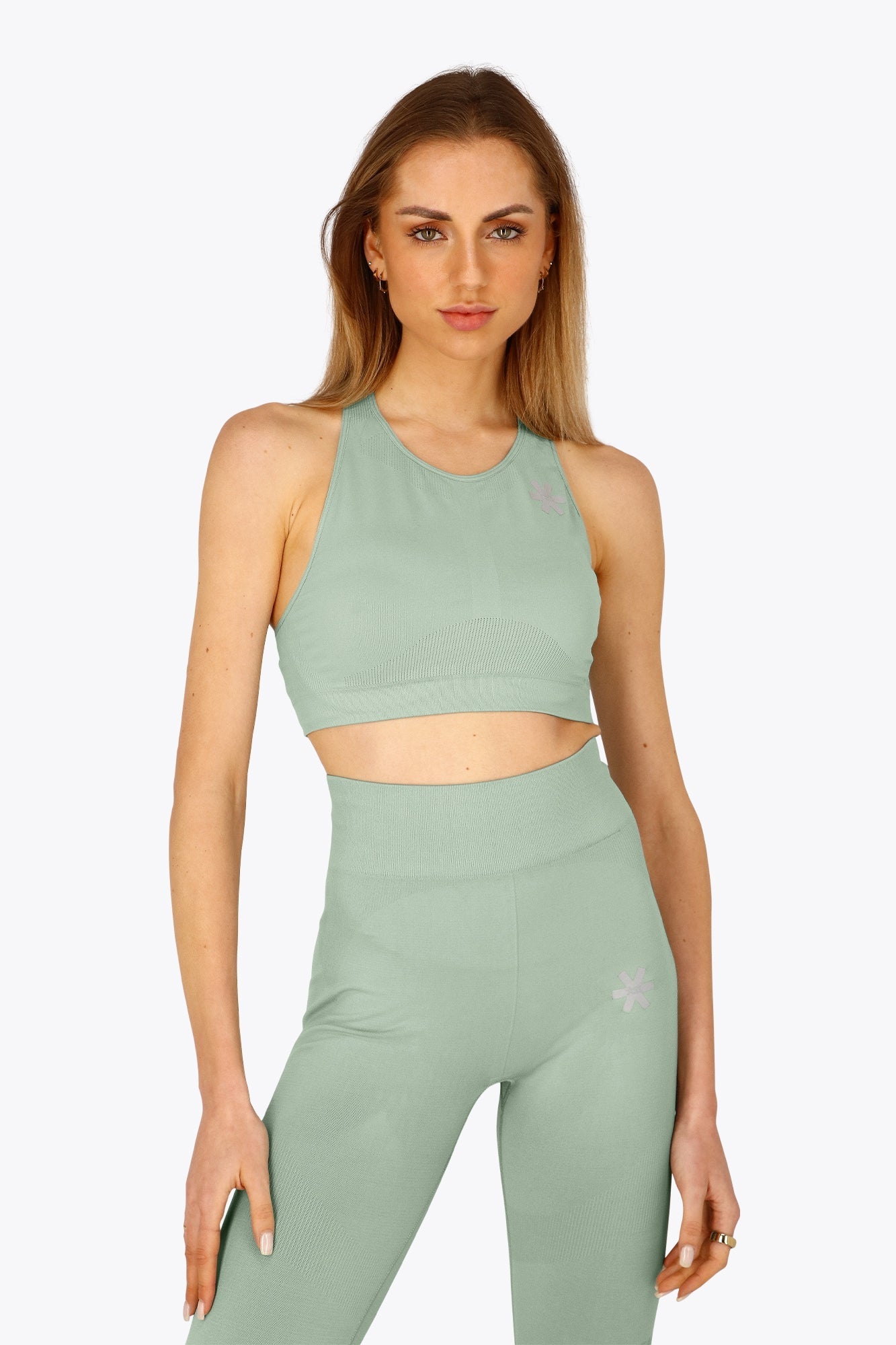 Woman wearing the Osaka women tech sports bra in jadeite with logo in grey. Front view
