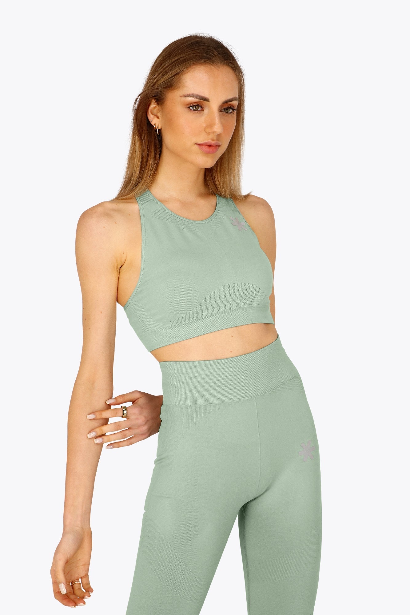 Woman wearing the Osaka women tech sports bra in jadeite with logo in grey. Front view