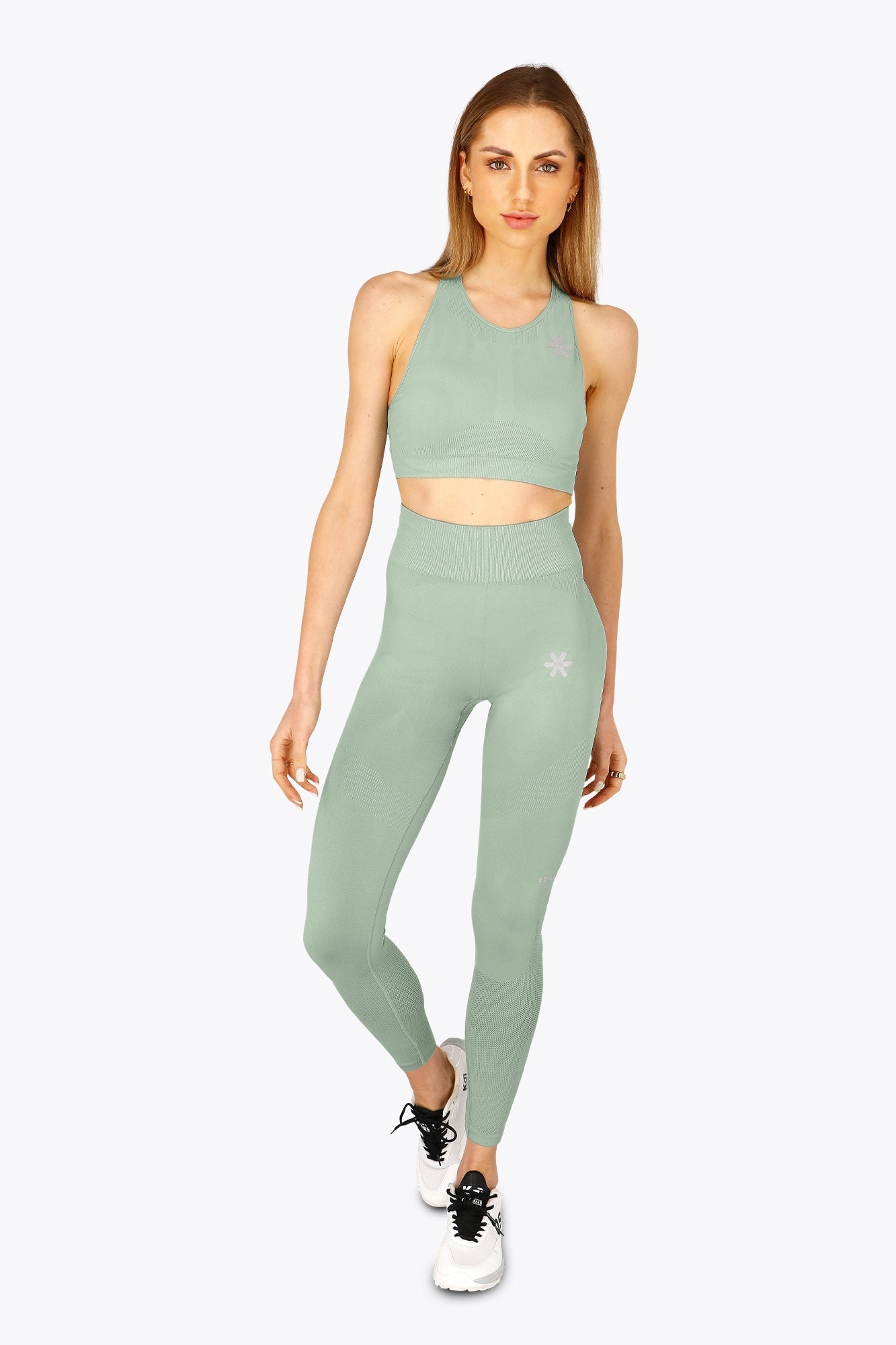 Woman wearing the Osaka women tech sports bra in jadeite with logo in grey. Front view