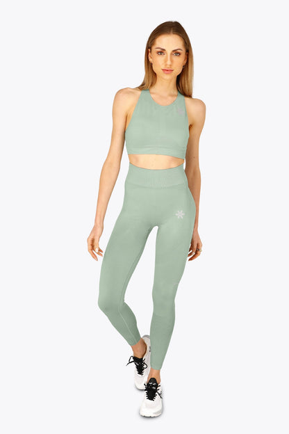 Woman wearing the Osaka women tech sports bra in jadeite with logo in grey. Front view