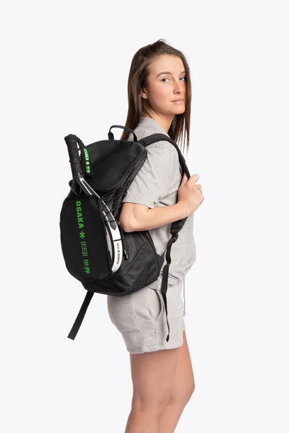 Osaka vision padel backpack in black with logo in green. Woman wearing the bag back view