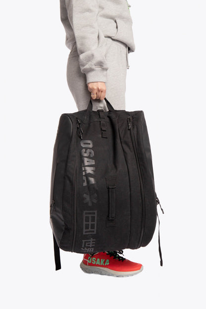 Pro Tour padel bag in black with logo in black. Woman holding the bag