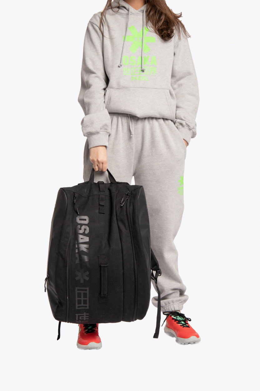 Pro Tour padel bag in black with logo in black. Woman holding the bag