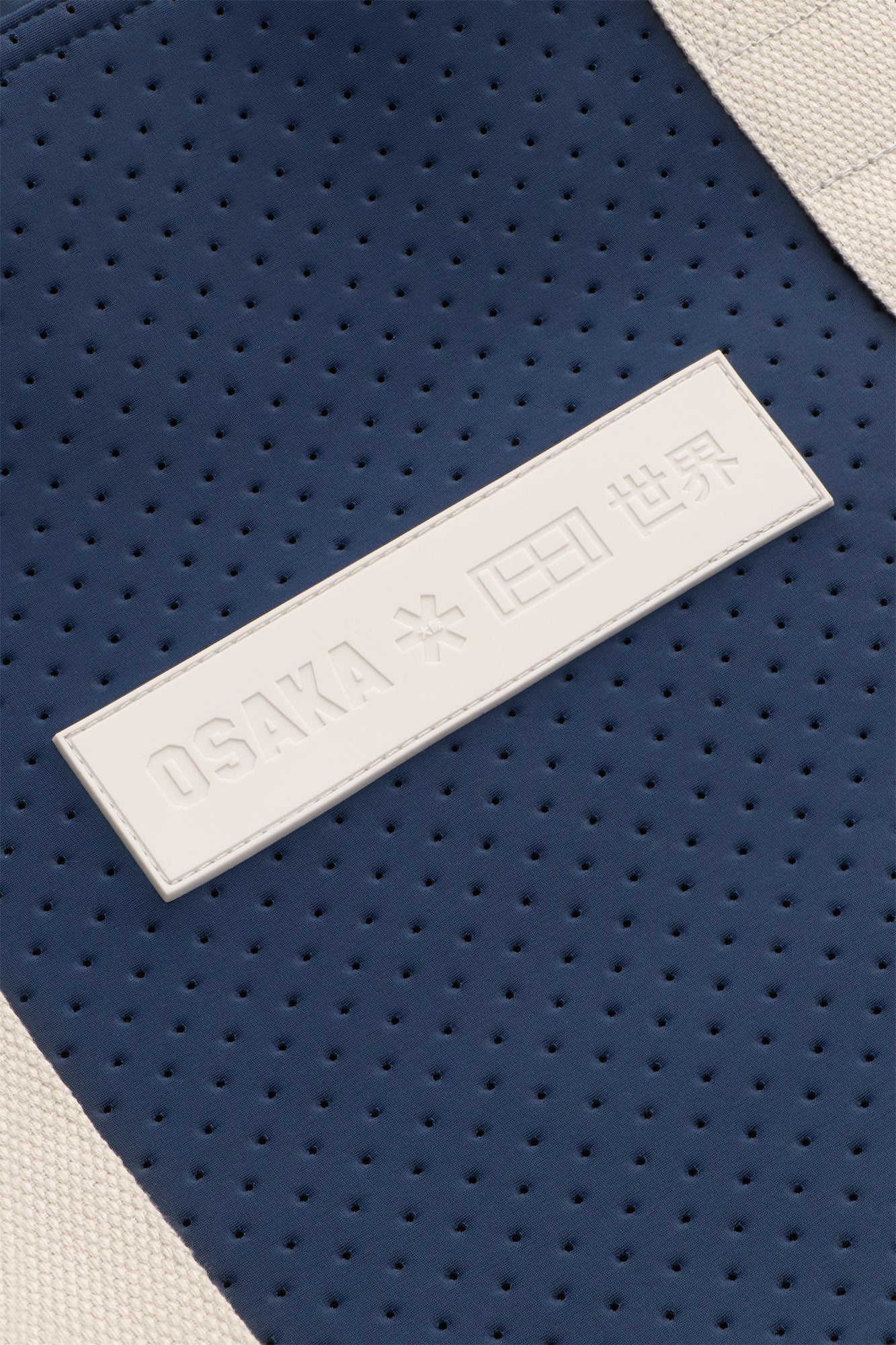 Osaka neoprene Tote bag in navy with structure and logo in white. Detail logo view