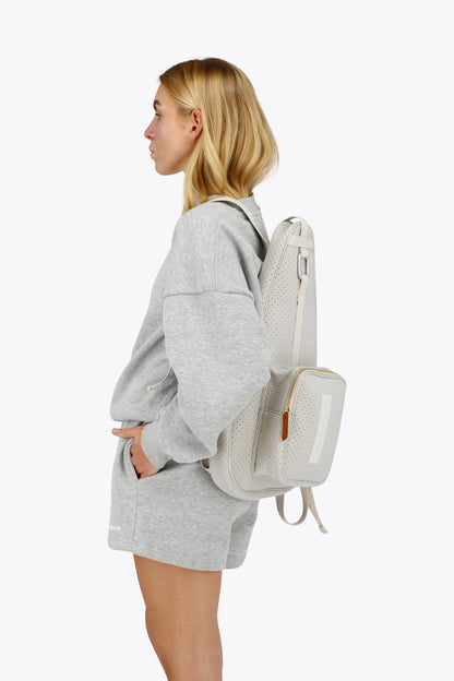 Osaka neoprene padel bag in light grey with structure and logo in white. Woman wearing the bag