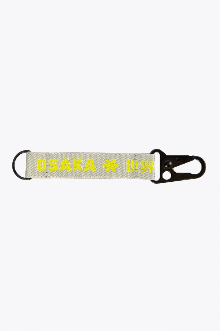 Osaka keychain in light grey with logo in yellow