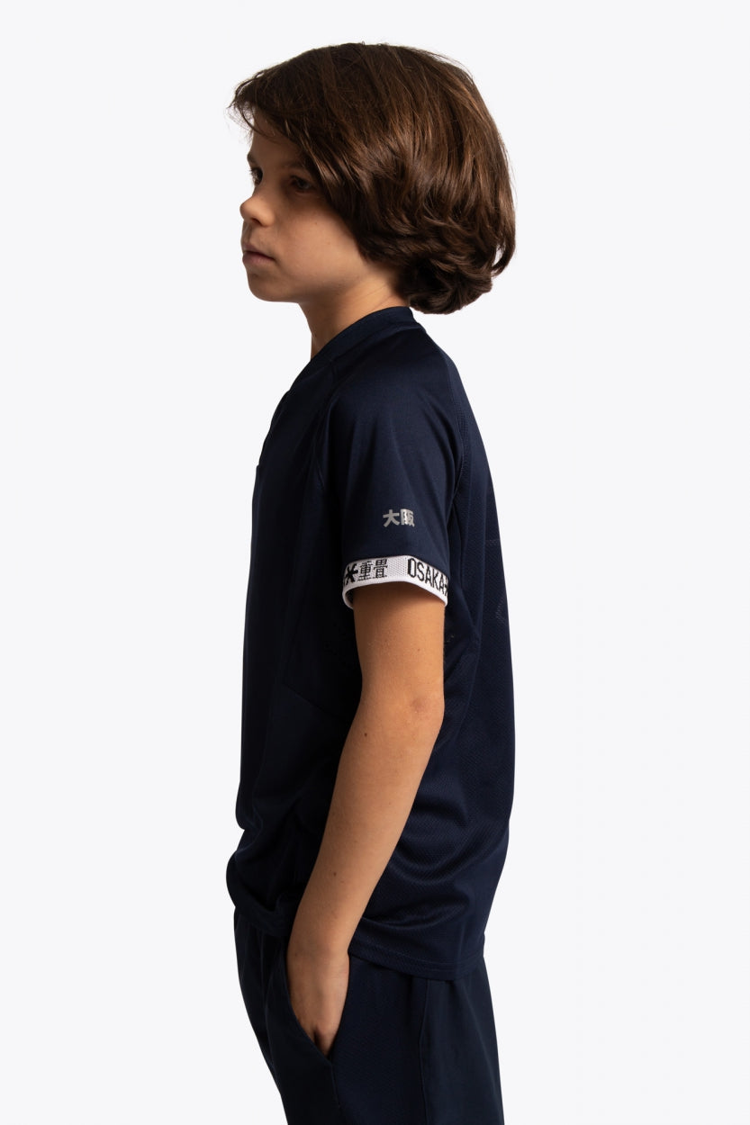 Boy wearing the Osaka Kids Jersey in Navy. Side view