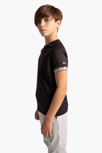 Boy wearing the Osaka Kids Jersey in Black. Side view