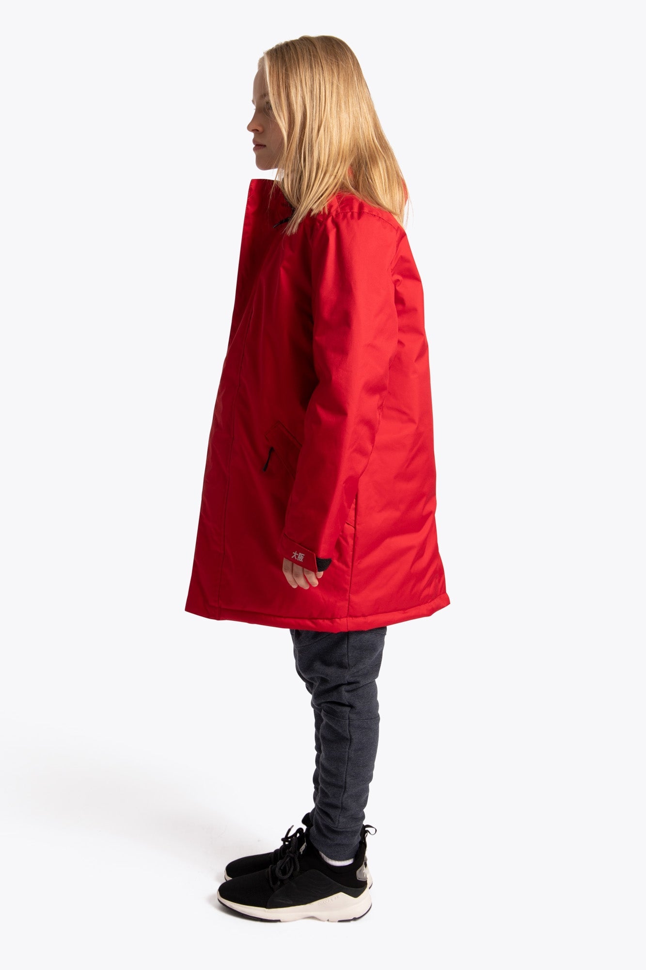 Boy wearing the Osaka Kids Stadium Jacket in Red. Side view