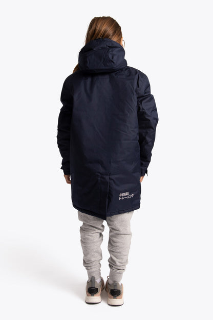 Boy wearing the Osaka Kids Stadium Jacket in Navy. Back view