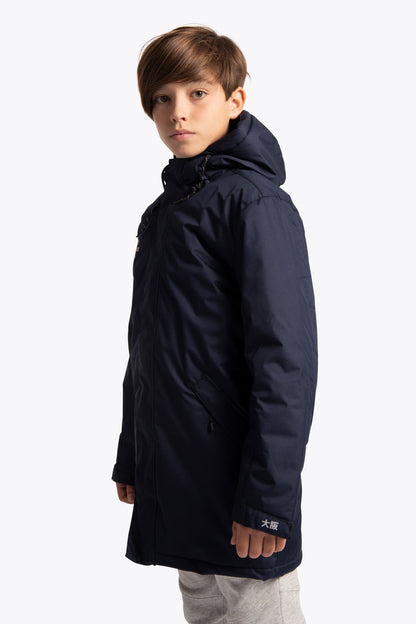 Boy wearing the Osaka Kids Stadium Jacket in Navy. Side view