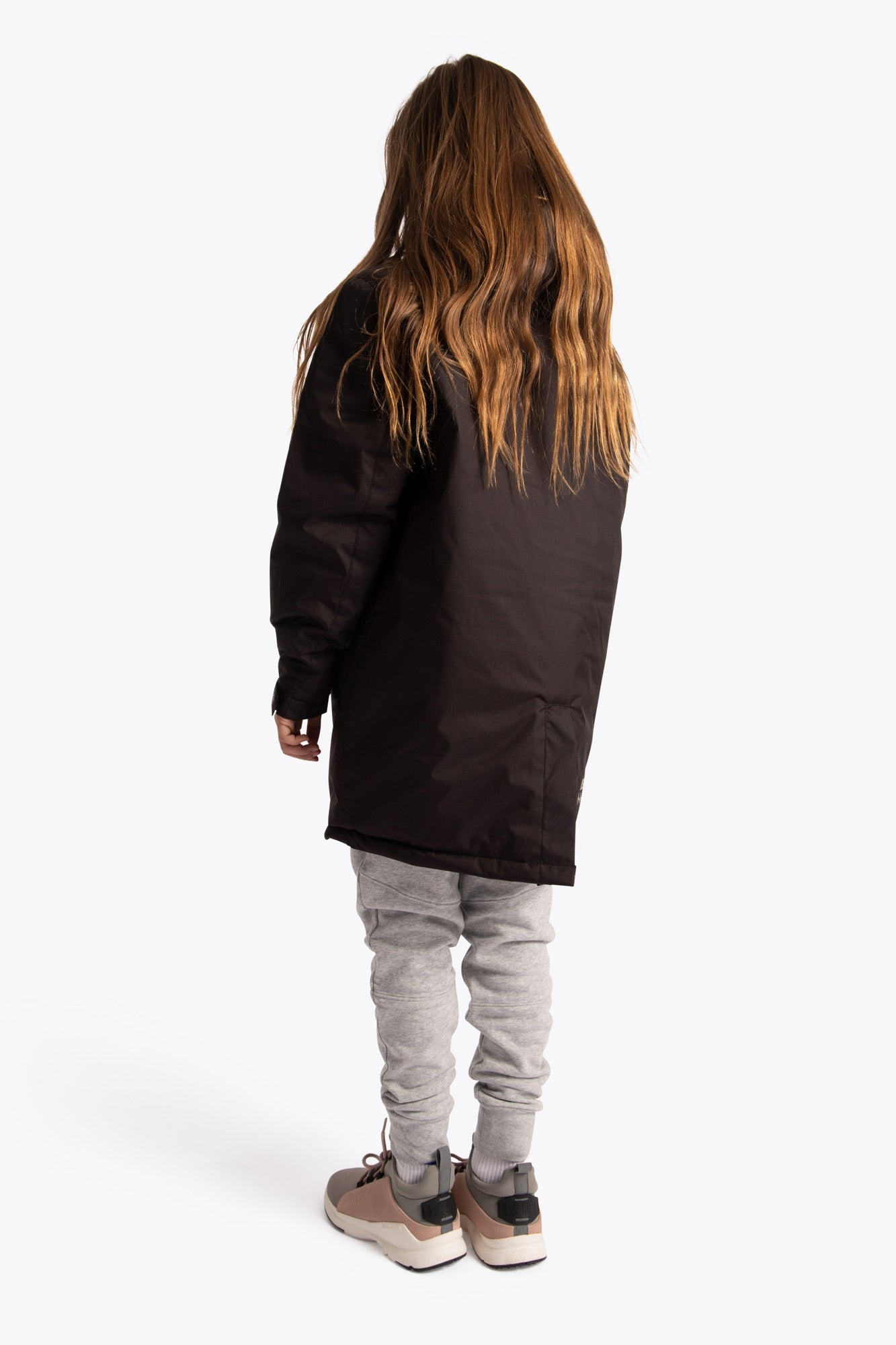 Girl wearing the Osaka Kids Stadium Jacket in Black. back view