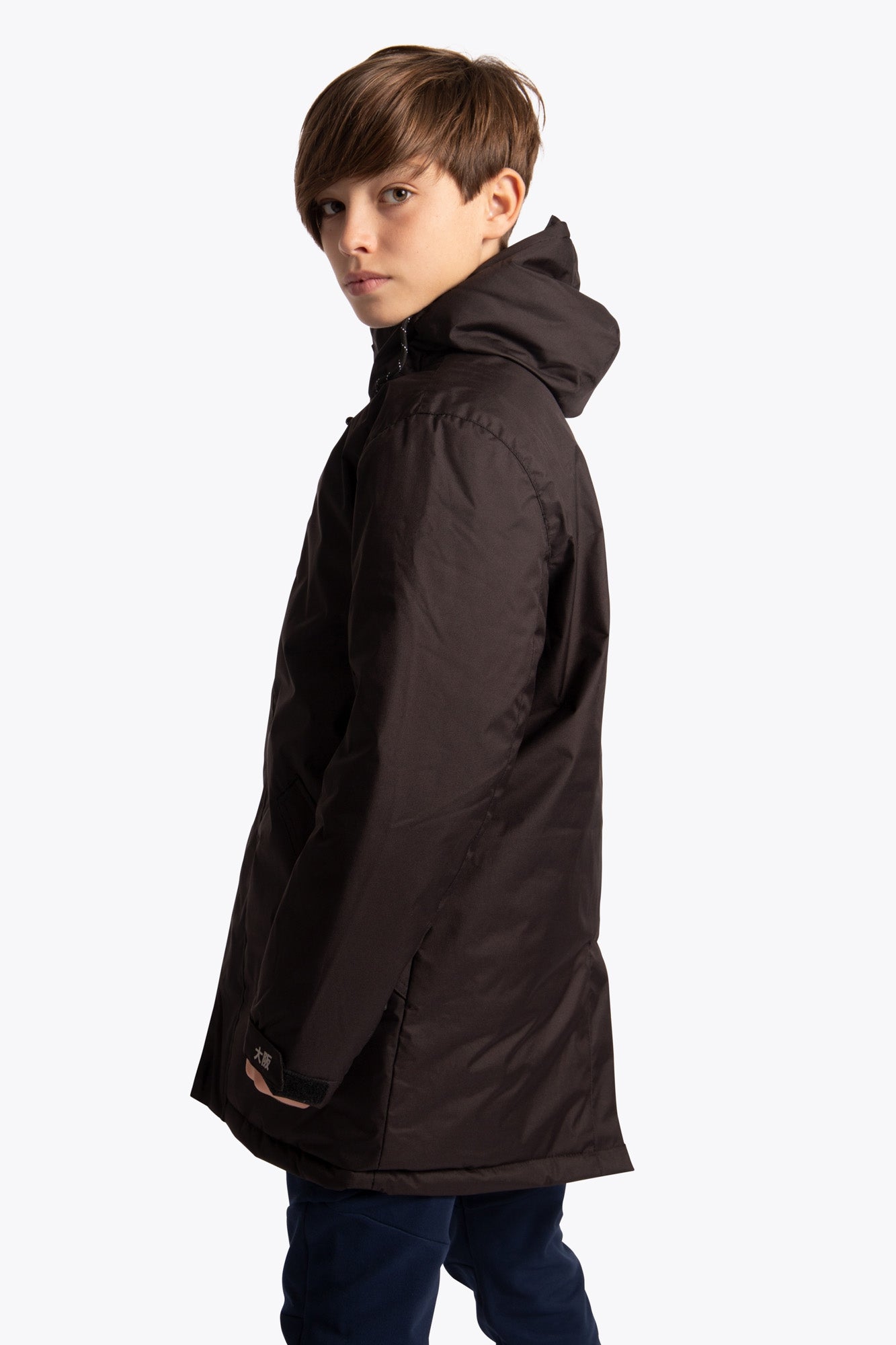 Boy wearing the Osaka Kids Stadium Jacket in Black. Side view