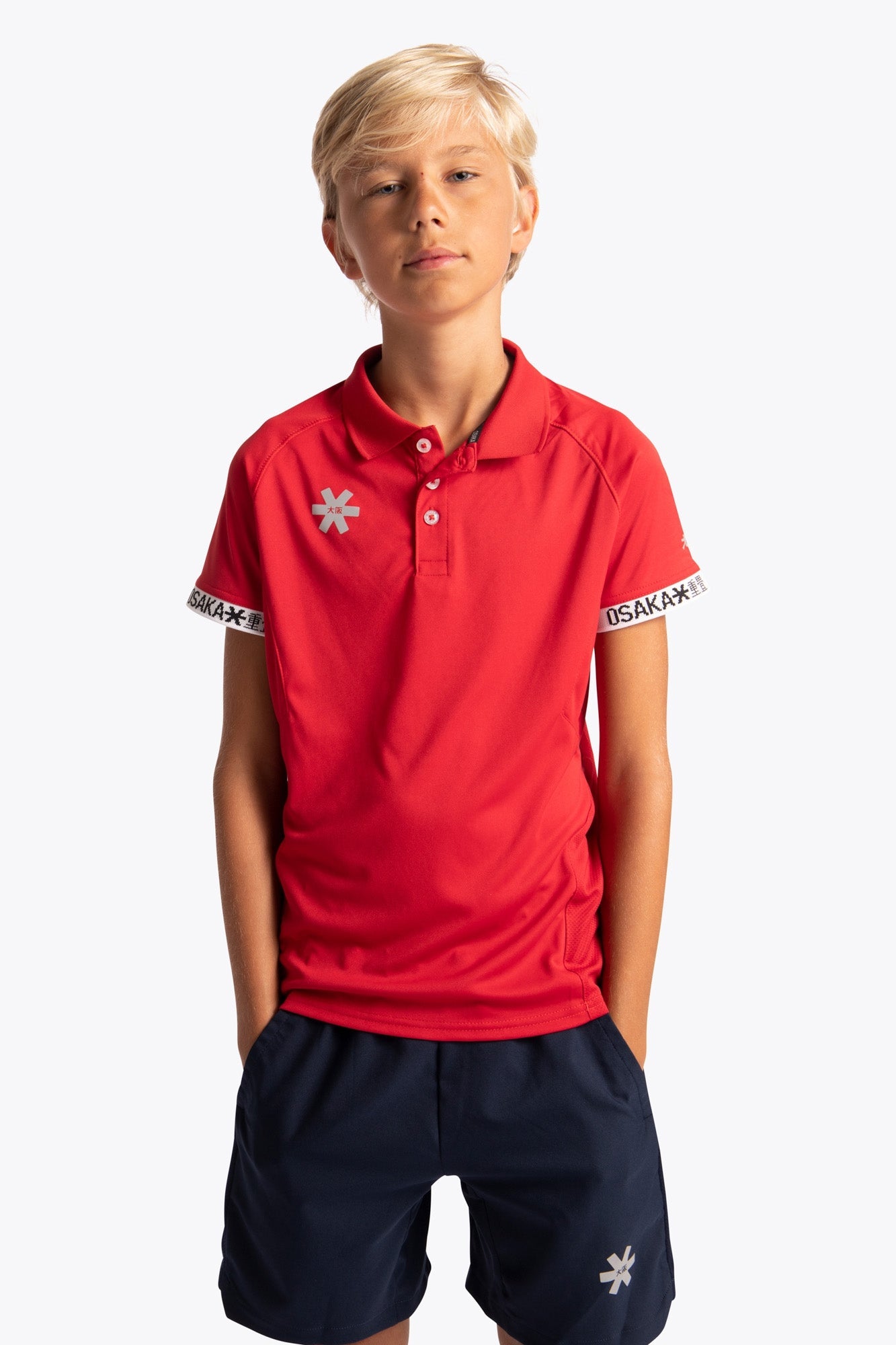 Boy wearing the Osaka Kids Polo Jersey in Red. Front view