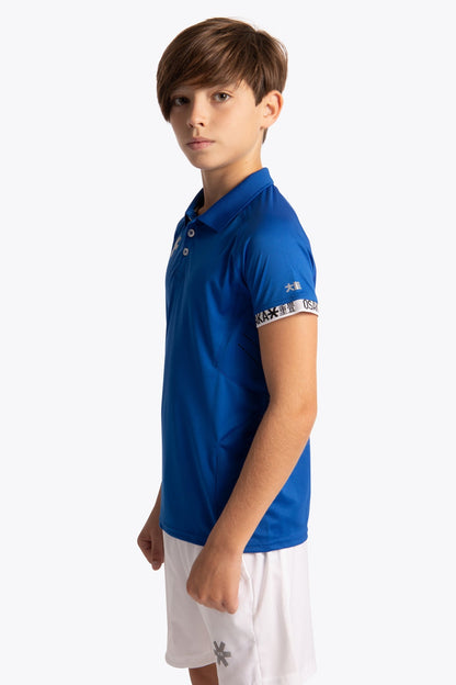Boy wearing the Osaka Kids Polo Jersey in Royal blue. Side view