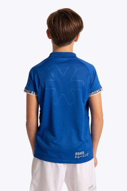 Boy wearing the Osaka Kids Polo Jersey in Royal blue. Back view